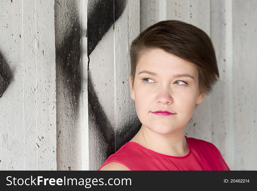 Portrait of young woman standing next to graffiti wall