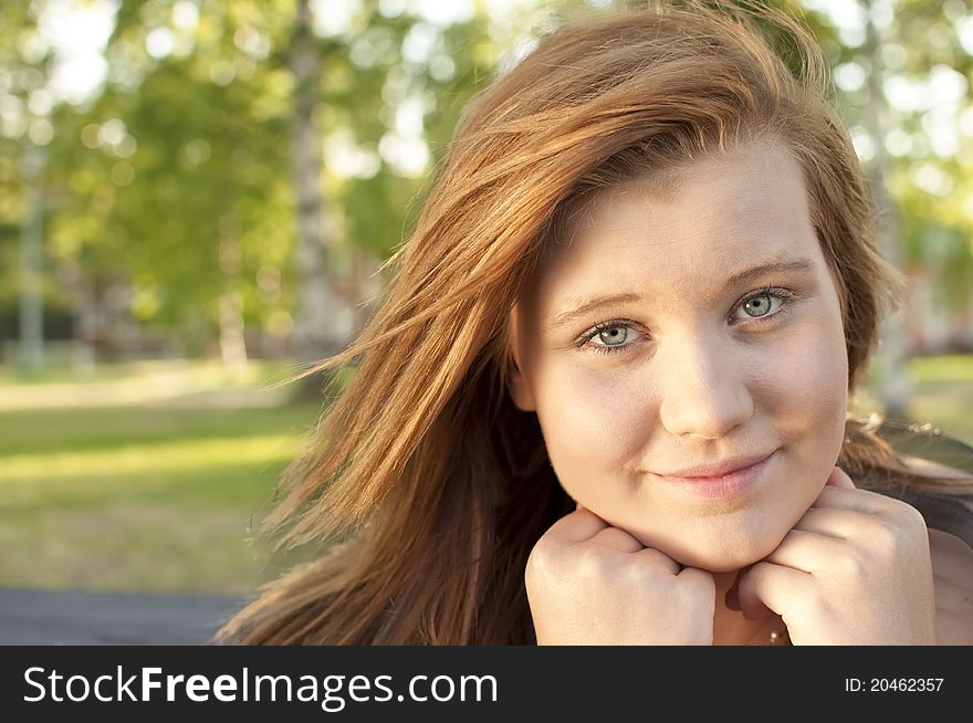 Young Woman Sitting On A Park Bench