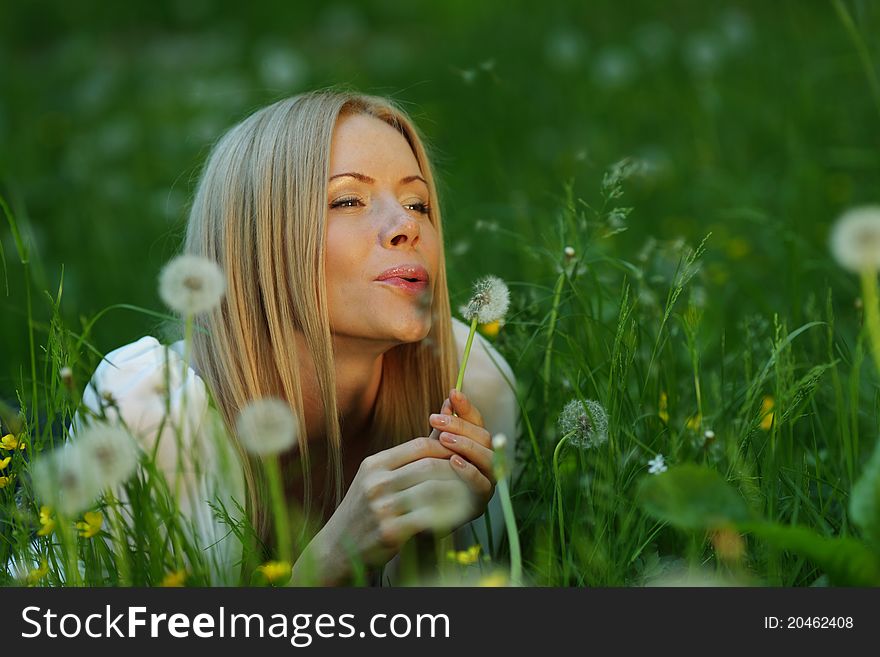 Girl blowing on a dandelion