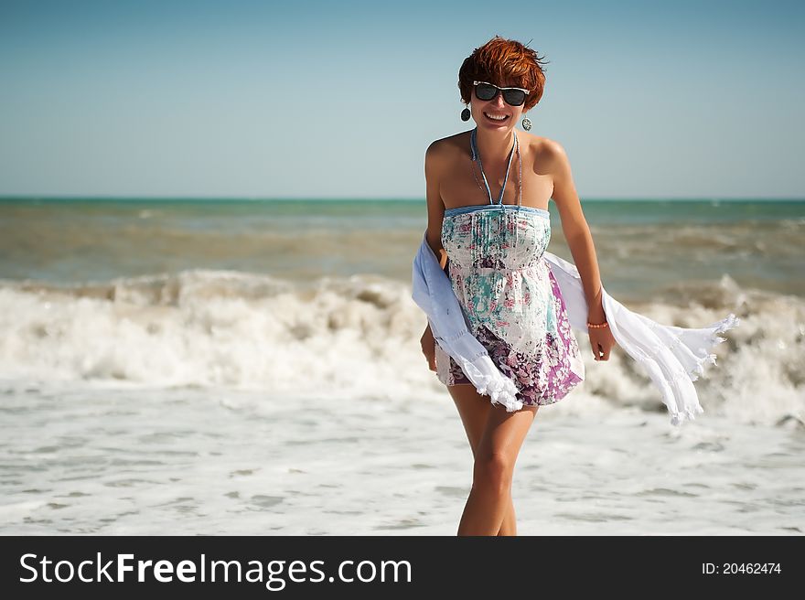 Young happy woman in summer dress standing in the sea. Young happy woman in summer dress standing in the sea