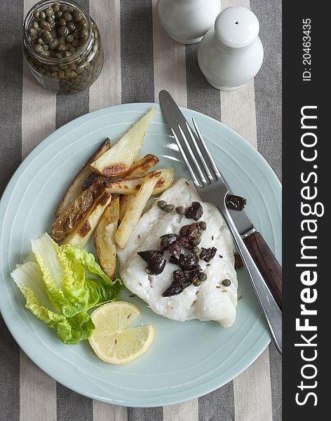 Cod with capers, black olives and potato chips with lettuce. Cod with capers, black olives and potato chips with lettuce