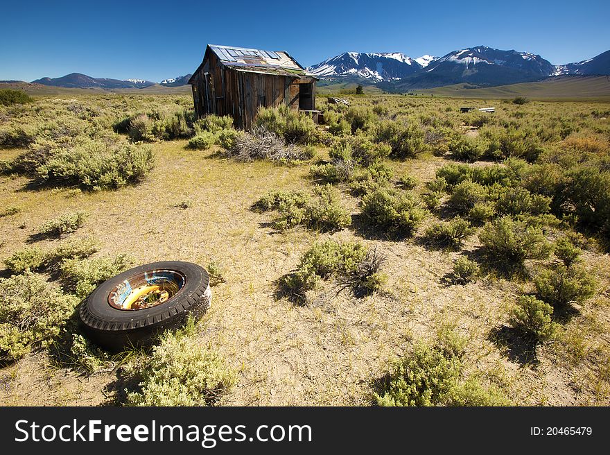 An abandoned house in front of a beautiful mountain range. An abandoned house in front of a beautiful mountain range.