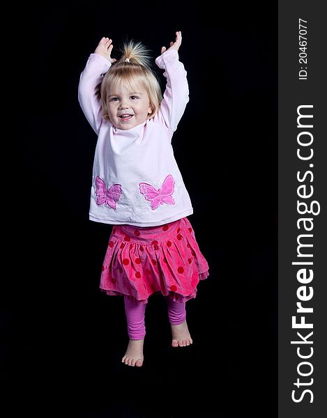 Closeup of a happy little girl against a black background