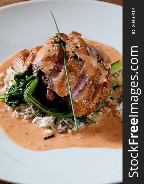 Grilled duck over greens and wild rice. Grilled duck over greens and wild rice