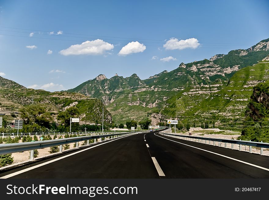 Blue sky, an extension of the highway in the mountains