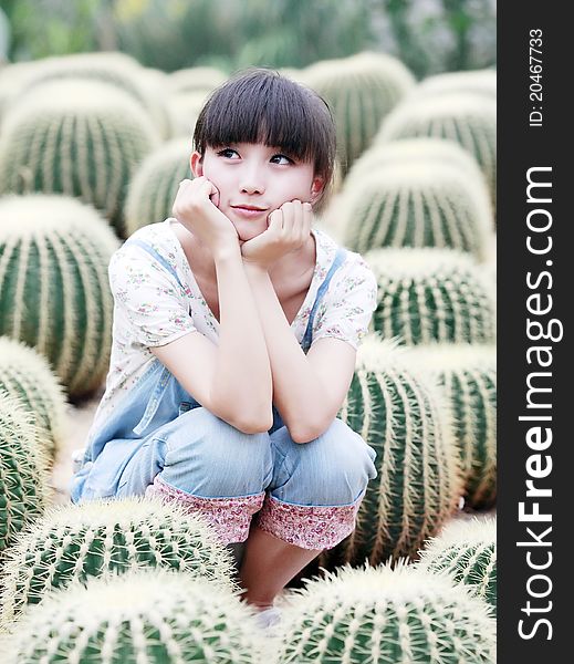 Charming Asian girl posing in ball cactus field. Charming Asian girl posing in ball cactus field.