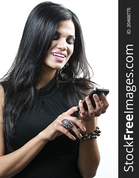 A Hispanic woman smiling as she looks at her cell phone. A Hispanic woman smiling as she looks at her cell phone