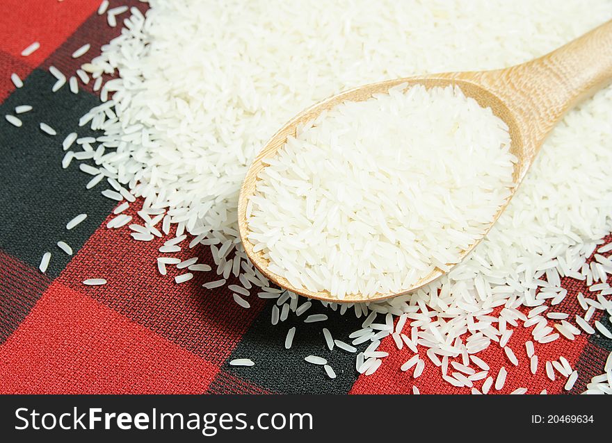 Rice grain and wooden spoon background