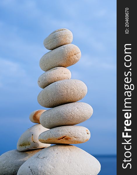 Balancing of white pebbles on the sea coast. Balancing of white pebbles on the sea coast