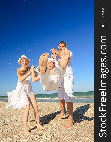 Boy flying on his parent's hands at beach. Boy flying on his parent's hands at beach