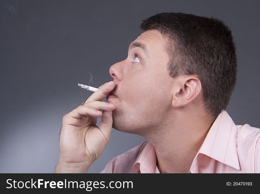 A Portrait Of A Young Man Smoking A Cigarette