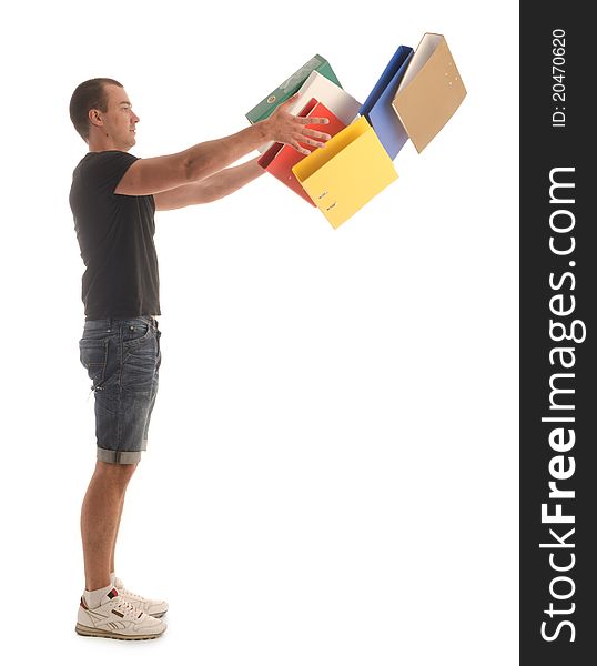 Young man in casual wear (shorts sneakers, shirt) stand throwing office folders into air. Young man in casual wear (shorts sneakers, shirt) stand throwing office folders into air