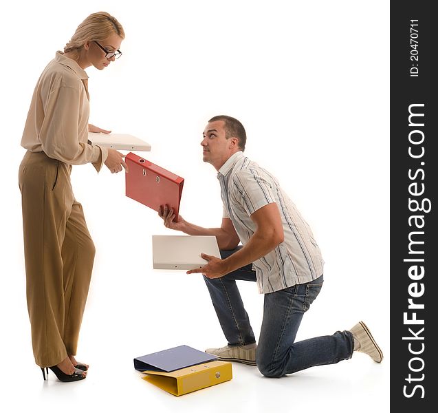 Man kneeling helps woman to pickup folders from ground. Man kneeling helps woman to pickup folders from ground