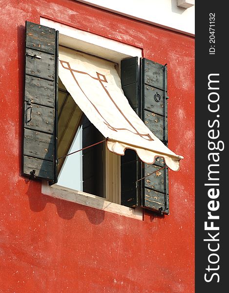 Old venetian window on red wall, Italy. Old venetian window on red wall, Italy