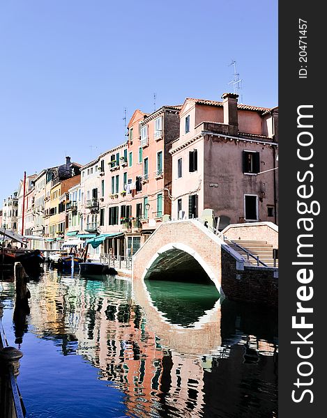 Bridge reflected in the water in Venice (Italy)