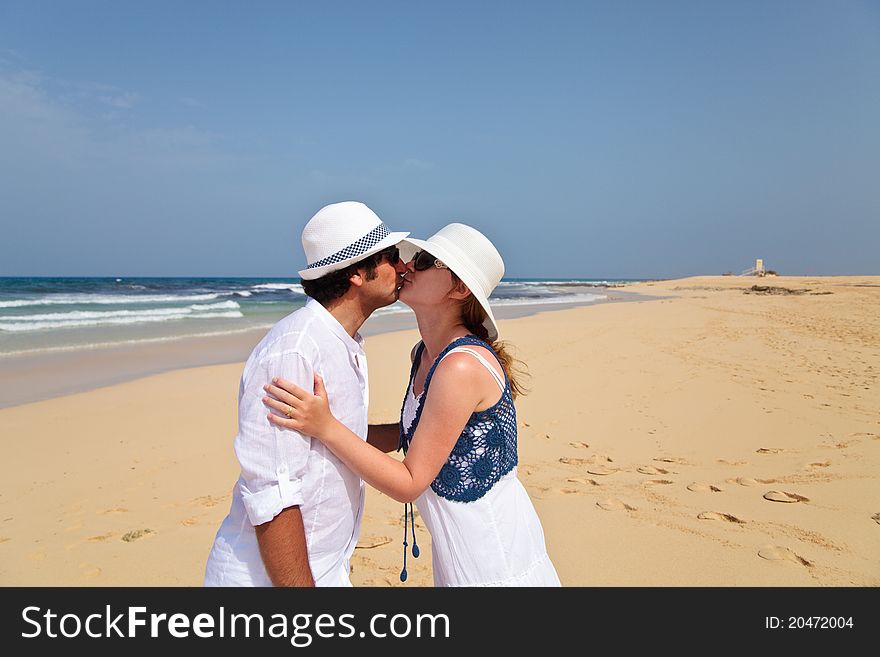 Couple, honeymooners kissing on a beach. Couple, honeymooners kissing on a beach