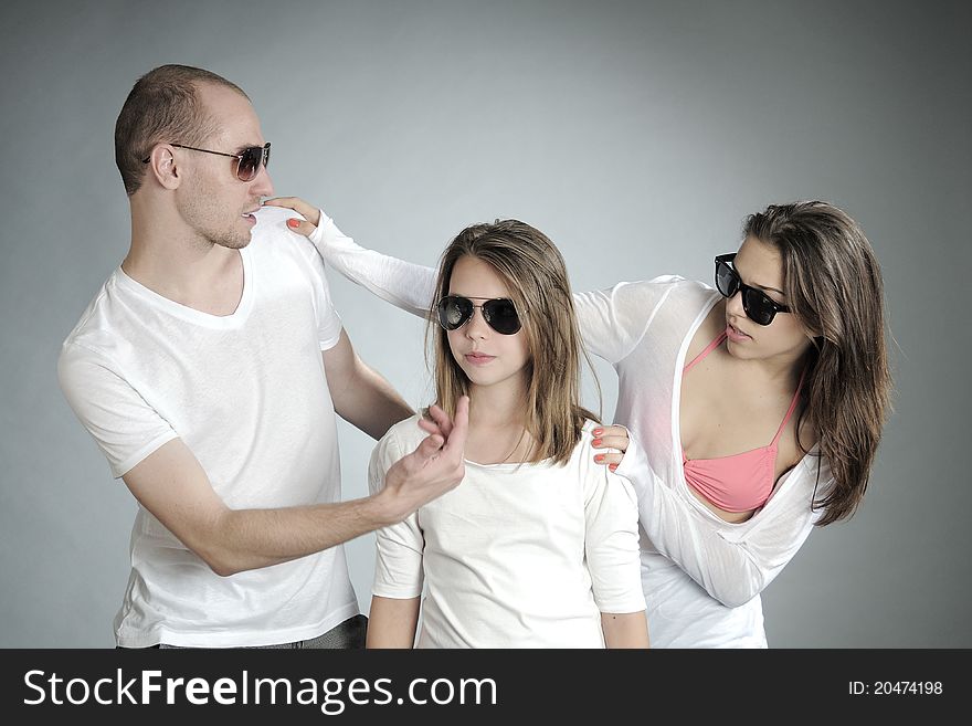 Pretty young people posing with sunglasses in studio. Pretty young people posing with sunglasses in studio