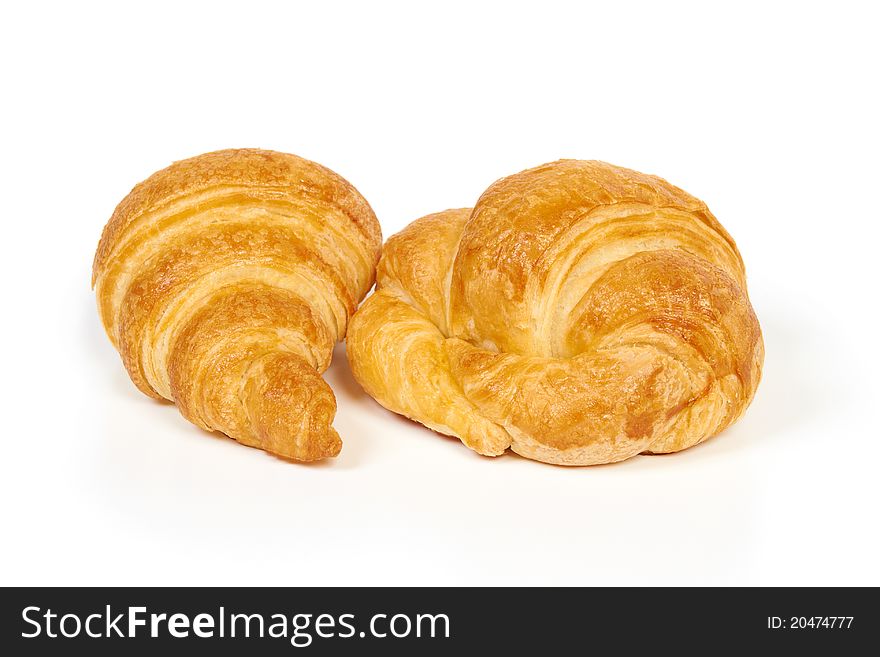 Two fresh and tasty croissants isolated on white. Two fresh and tasty croissants isolated on white