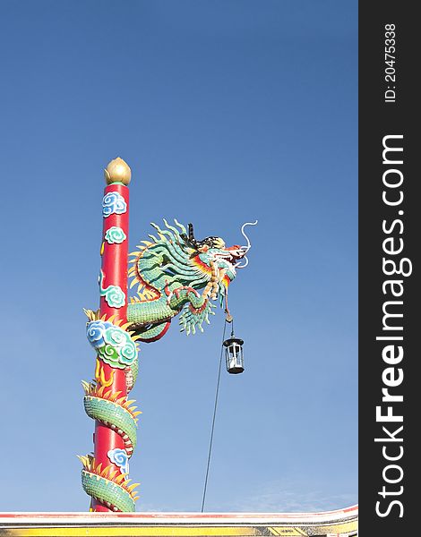 Red dragon climbing the pole. Northern Chinese temple, blue sky. Red dragon climbing the pole. Northern Chinese temple, blue sky.