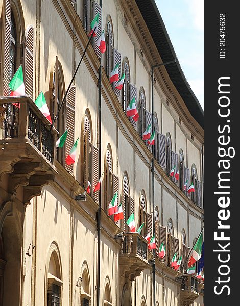 Some Italian flags outside of a windows