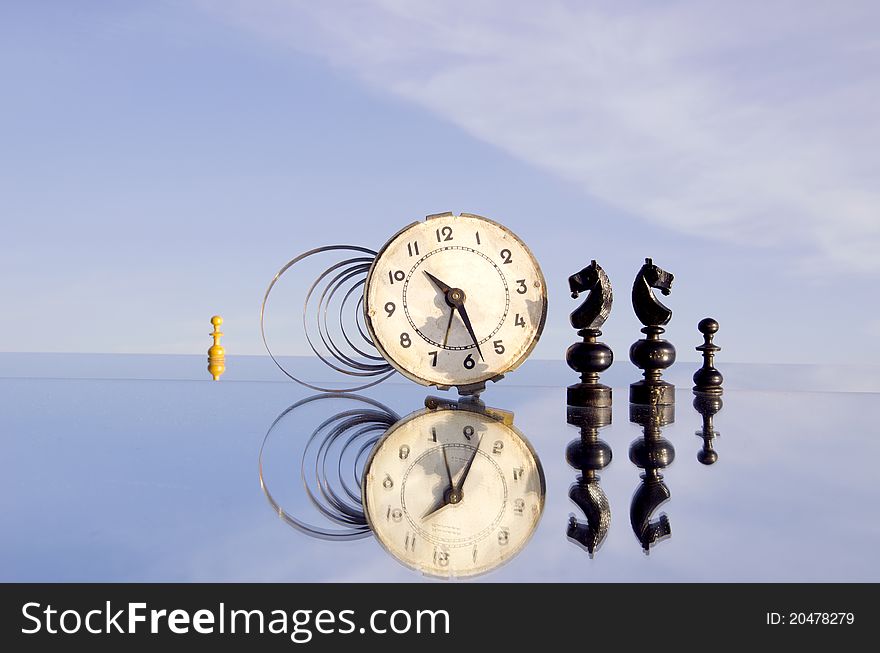 clock and chessmans on mirror