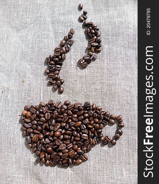 A picture of a cup of coffee made from coffee beans, on linen cloth.