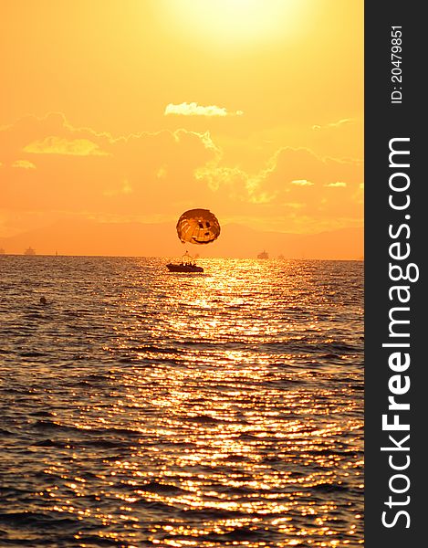 Boat with a parachute at sunset