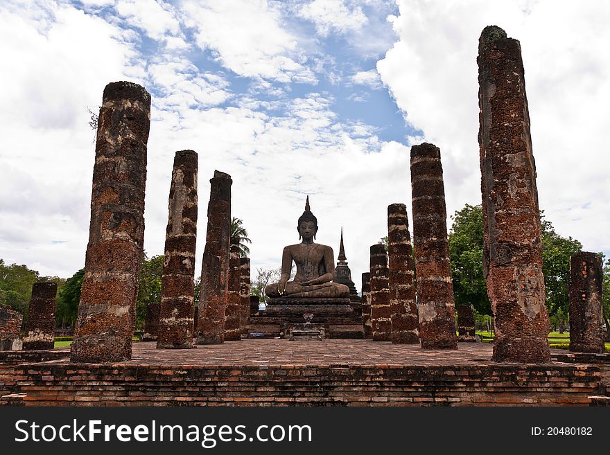 Ruin Buddha statue among ruin pillars in Sukhothai historic park. Ruin Buddha statue among ruin pillars in Sukhothai historic park