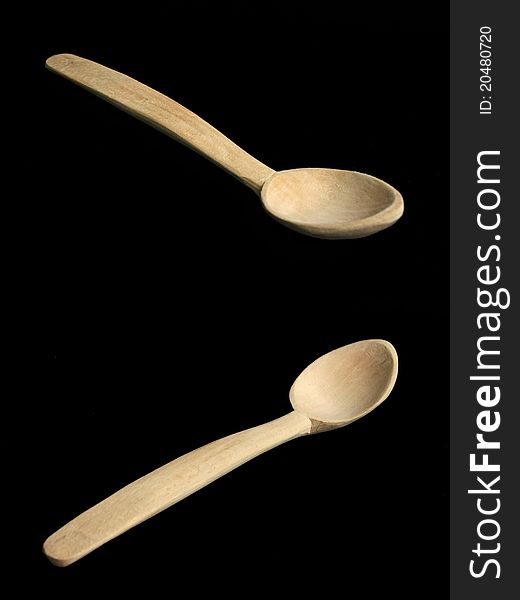 Two views of a wooden spoon on black background. Isolated.