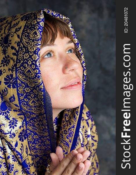 Beautiful woman smiling with shawl praying