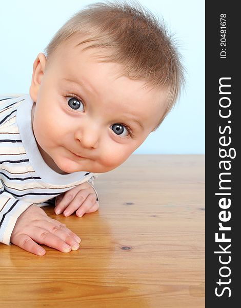 Beautiful 6 month old baby boy against blue background