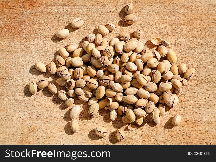 Roast salt pistachios on wooden board outdoor in summer evening