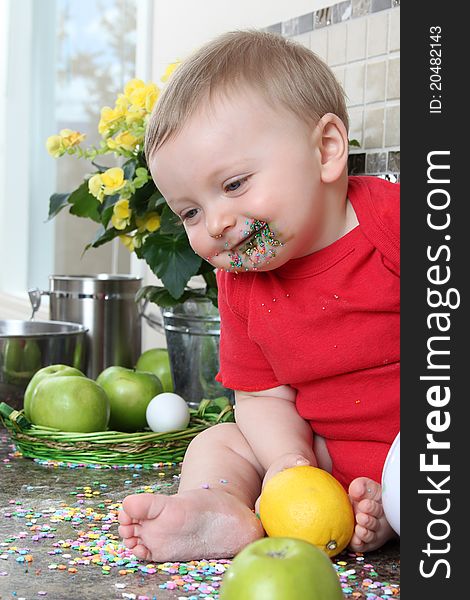 Baby boy playing on messy counter top. Baby boy playing on messy counter top