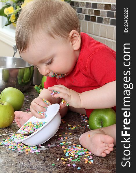 Baby boy playing on messy counter top. Baby boy playing on messy counter top