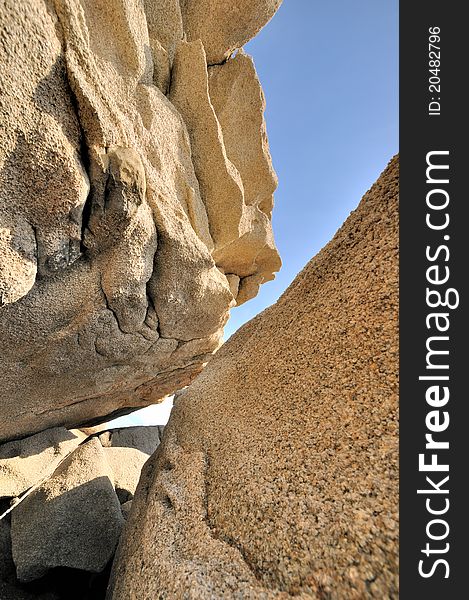 Rocks with featured texture under blue sky.