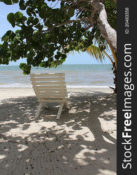 A chair in the shade facing the Caribbean