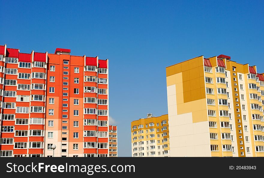 Multistory yellow and red houses on the background of blue sky