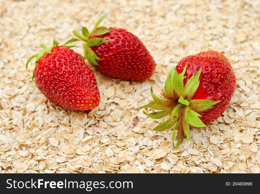 Ripe strawberries on background of dry oat, healthy eating concept