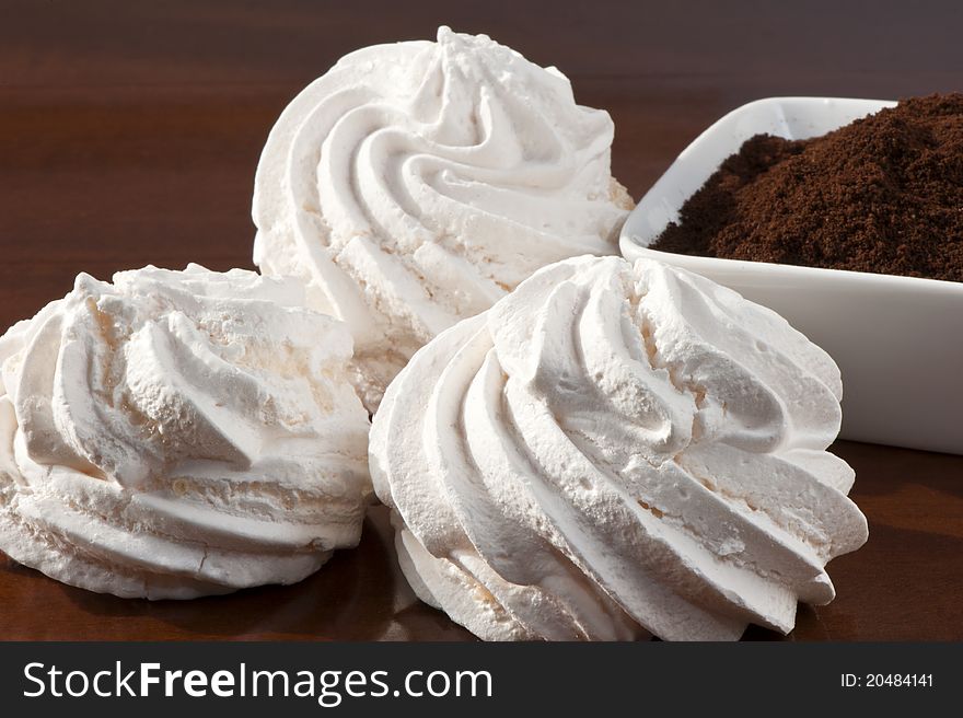 Meringues and coffee powder of wooden board