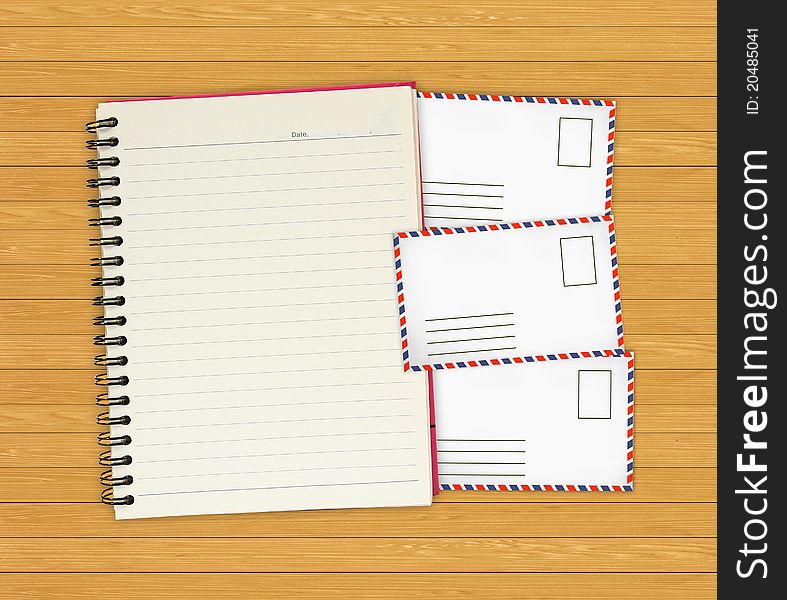 Note book with Old envelopes on wooden background for design-works