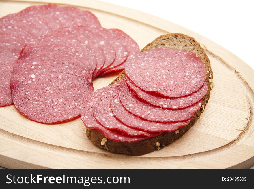 Paprika salami on bread with wood plate