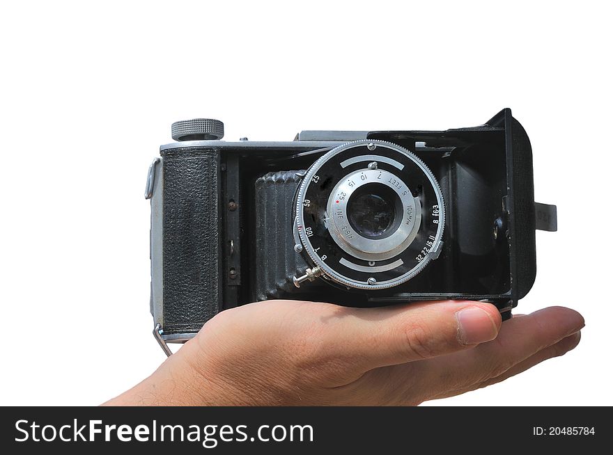 Old camera lies in the palm of the photographer isolated against a white background