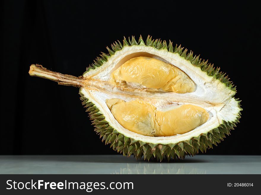 Close up of durian on marble surface over black background.