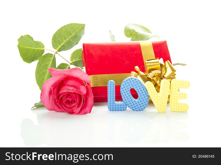 Beautiful red rose, a red gift box and the text LOVE. Isolated on a white background. Beautiful red rose, a red gift box and the text LOVE. Isolated on a white background