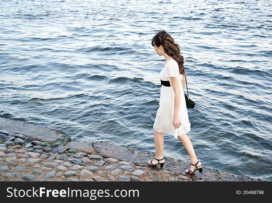Young beautiful girl on against the background of water