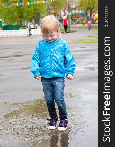 A girl is jumping in the puddle