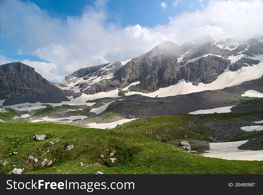 Mountain landscape with snow and clouds