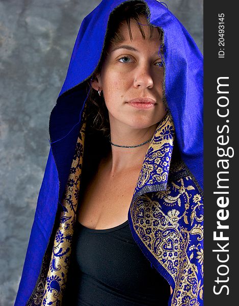 Portrait of a beautiful mystical woman looking at viewer her head is covered with blue hood. Portrait of a beautiful mystical woman looking at viewer her head is covered with blue hood.