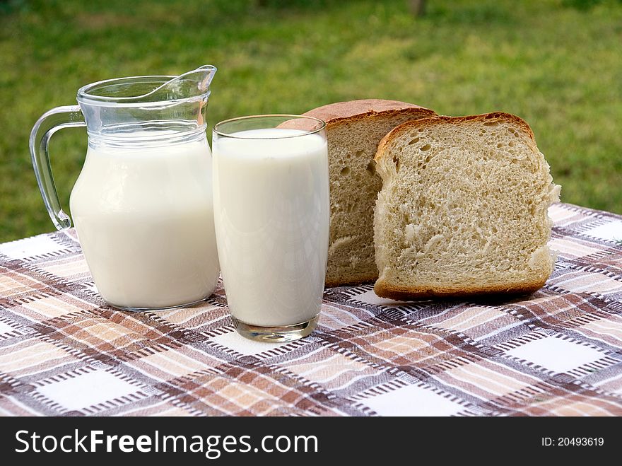 Milk and bread on table in garden. Milk and bread on table in garden