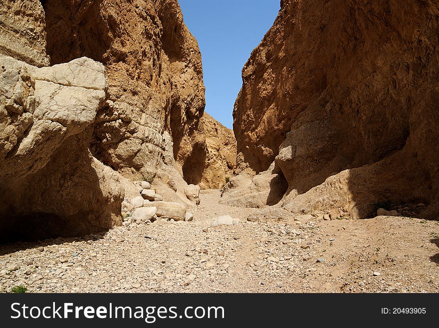 Narrow orange desert canyon with high limestone walls